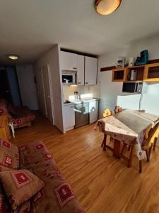 ein Wohnzimmer mit Tisch und Küche in der Unterkunft Reine Blanche Condo By AlpineStay in Val Thorens