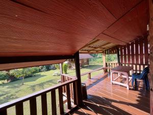 a wooden porch with a table and chairs on it at Angha forest view บ้านพิงใจ in Ban Sop Mae Klang