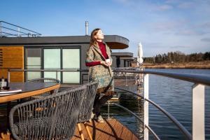 a woman standing on the deck of a boat at Hausboot Bellini in Klitten