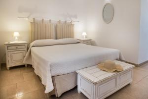 a bedroom with a bed with a hat on a table at Antica Masseria Ficazzana - Tenuta in Marina di Pescoluse