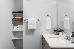 a white bathroom with a sink and a mirror at Studio Apt in the Center of Downtown by Cozysuites in Indianapolis
