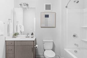 a white bathroom with a toilet and a sink at Studio Apt in the Center of Downtown by Cozysuites in Indianapolis +12 photos