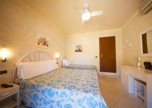 a bedroom with a bed with a blue and white comforter at Hotel Danila in Portoferraio