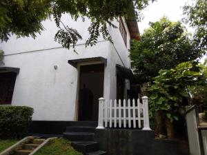 a white house with a white fence in front of it at wije residence in Ambalangoda