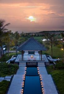 a resort pool with a gazebo at sunset at New Kuta Hotel by LORIN in Uluwatu
