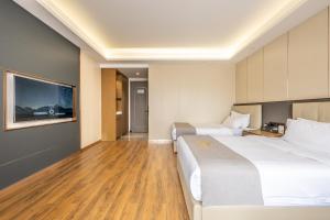 Postel nebo postele na pokoji v ubytování Bole Jing Pin Hotel