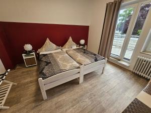 Un dormitorio con una cama con una pared roja. en 3 x Ferien- & Monteurwohnungen Koenen nah am Westfield Centro, en Oberhausen