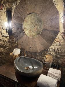 a stone bathroom with a sink and a mirror at Selene Luxury Rooms in Sinevrón +74 photos