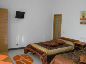 a bedroom with two beds and a wall at Casa Rustica in Focşani