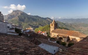 a view of roofs of buildings with mountains in the background at apartamento Dolina in Segura de la Sierra