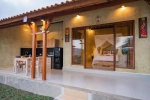 a house with a patio with a table in it at Soka Villa in Ubud