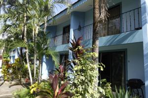 a blue building with palm trees in front of it at Coco Maya 2b2b Villa in Coco