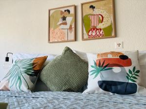 een bed met kussens en schilderijen aan de muur bij Erlenmatt in Bazel