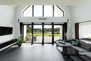 a living room with a couch and a large window at Villa Monster in Mrągowo