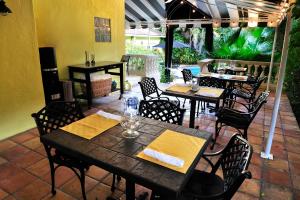 un restaurant avec des tables et des chaises et une terrasse dans l'établissement Mango Inn Bed and Breakfast, à Lake Worth