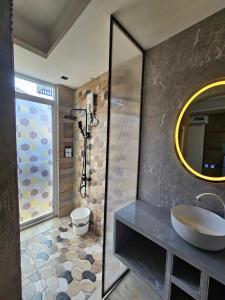 a bathroom with a sink and a toilet and a mirror at Hotel Pressie by SMS Hospitality in Panglao