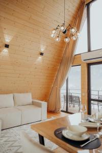 a living room with a white couch and a table at Memories Carpaty in Mizhhirʼʼya