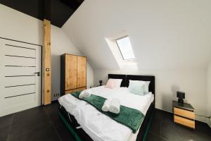 a bedroom with a bed with two towels on it at Villa Monster in Mrągowo