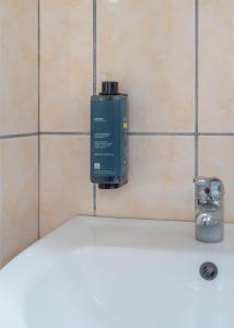 a blue soap dispenser on a wall next to a sink at Ermioni Rooms in Paralia Vrachou