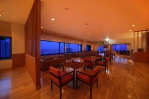 a dining room with tables and chairs and windows at ANA Crowne Plaza Kobe by IHG in Kobe