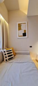 a bedroom with a white bed with a picture on the wall at Cocohut Beach Resort Koh Phangan in Haad Rin