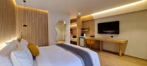 a hotel room with a bed and a desk with a television at Cocohut Beach Resort Koh Phangan in Haad Rin