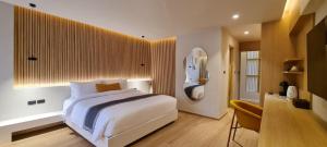 a bedroom with a large white bed and a mirror at Cocohut Beach Resort Koh Phangan in Haad Rin