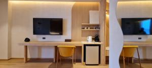 a room with a desk with two chairs and a television at Cocohut Beach Resort Koh Phangan in Haad Rin