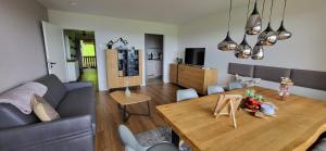 a living room with a couch and a wooden table at Almchalet mit Pool und Sauna, nah am Bikepark Weitnau, direkt am Skilift in Missen-Wilhams