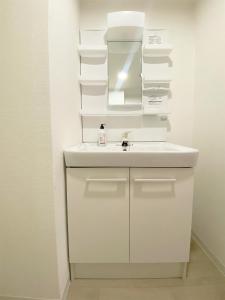 Un baño blanco con lavabo y espejo. en The Inui N5, en Tokio