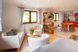 a living room with white furniture and a kitchen at Chata Juta Horní Bečva in Horní Bečva