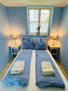 a bedroom with two beds with blue walls and a window at Lateinschule in Tecklenburg
