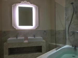y baño con 2 lavabos, espejo y bañera. en Grosvenor Hotel Rugby, en Rugby
