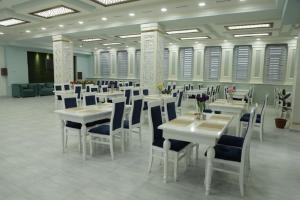 a dining room with white tables and chairs at Ахсикент отель in Namangan