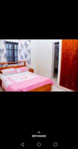 a bedroom with a bed with a pink bedspread at Ouslane Appart in Cotonou +2 photos