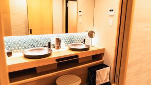 a bathroom with two sinks and a large mirror at Tabist kiki HOTEL KYOTO Gojo Karasuma in Kyoto