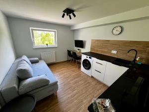 a living room with a couch and a clock on the wall at Apartament Wojska Polskiego 45 in Wadowice
