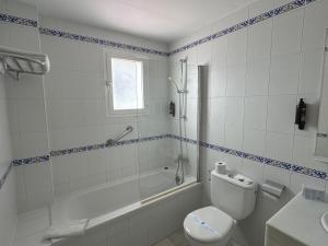a bathroom with a toilet and a tub and a sink at Hotel Nerja Club by Dorobe in Nerja
