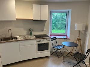 a kitchen with white appliances and a table and a window at FlaKturm Wertheim in Wertheim