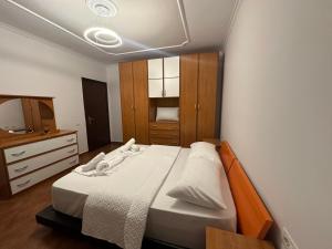 a bedroom with a bed and a dresser and a television at Elois Center Apartament in Tirana