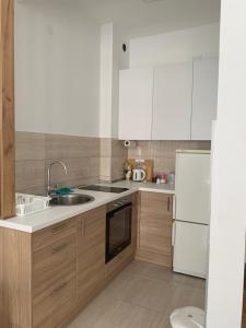 a kitchen with white cabinets and a sink and a refrigerator at Apartman Andreja in Trebinje