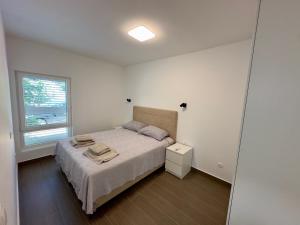 a white bedroom with a bed and a window at Villa Jolanda Beachside Residence in Orebić