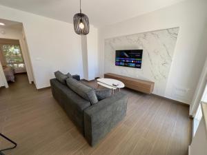 a living room with a couch and a tv at Villa Jolanda Beachside Residence in Orebić
