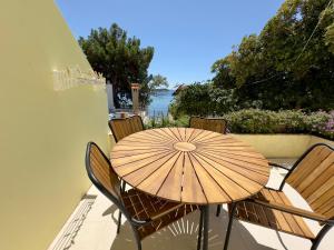 a wooden table and chairs on a balcony with an umbrella at Villa Jolanda Beachside Residence in Orebić