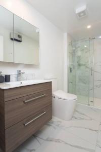 a bathroom with a toilet and a glass shower at Stellar Central City Apartment - Hagley Park in Christchurch