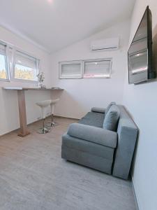 a living room with a blue couch and a desk at Villa Grande in Neum