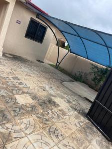 a building with a stone floor with a blue roof at 2 Bedroom House in Accra in Accra +4 photos