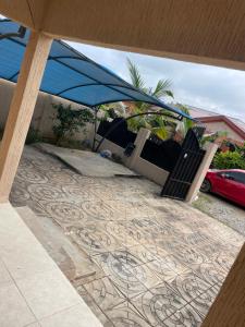 a person laying in chairs under a tent on a patio at 2 Bedroom House in Accra in Accra