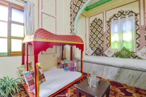 斋浦尔FabHotel Prism Homestay的配有床和桌子的房间