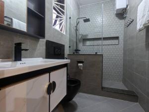 a bathroom with a sink and a toilet and a shower at Cozy 1 BR APT in Kampala on Mutungo Hill in Kampala +21 photos